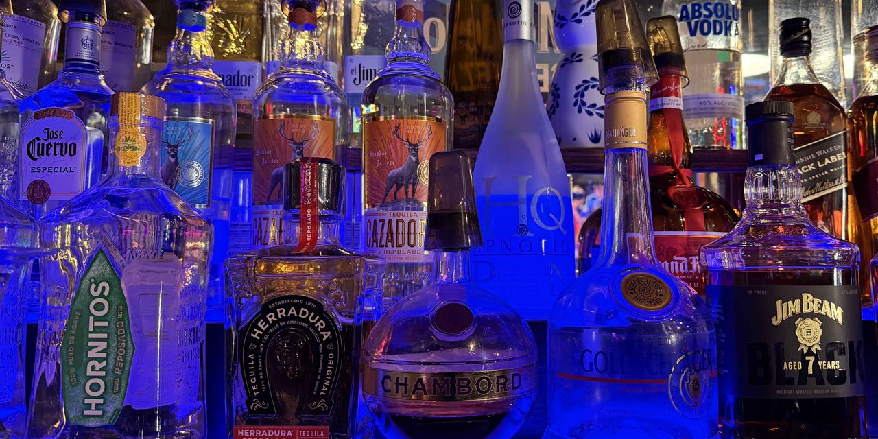 Back bar at Dingers Sports Bar lit in blue, with Hornitos, Herradura, Jose Cuervo Especial, Cazadores, Chambord, and Jim Beam on the shelves.